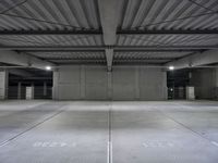 an empty parking garage with a sign indicating to wait for the next step down stairs