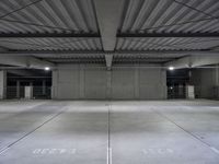 an empty parking garage with a sign indicating to wait for the next step down stairs