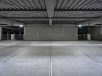 an empty parking garage with a sign indicating to wait for the next step down stairs