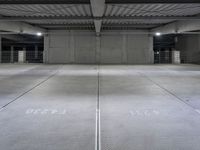 an empty parking garage with a sign indicating to wait for the next step down stairs