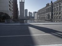 a long street in an urban area, with many buildings in the background and people crossing over it