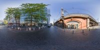 a fish eye view of a street with cars driving in it's direction, and a building in the background