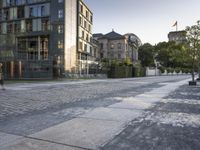 a man riding his skateboard on an empty street near buildings with clock towers in the background