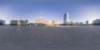 a circular view of a city with high rise buildings and pedestrians walking in the foreground