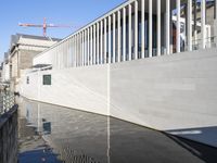 an art museum reflected in a body of water on the surface is building a white building