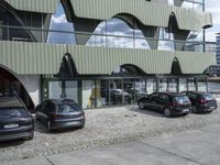 an image of an outdoor view of three different cars parked next to each other and in front of the building