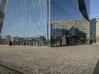 a group of buildings are reflected in a mirrored glass building window in berlin, germany