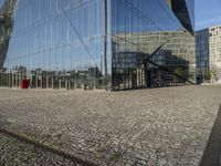 a group of buildings are reflected in a mirrored glass building window in berlin, germany