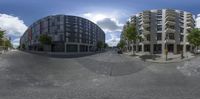 an image taken from a 360 - view of a street corner in front of a tall building