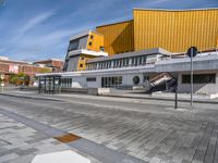 a concrete block on the sidewalk in front of a yellow building and another concrete block on a sidewalk