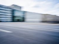 a person is riding a motorcycle on a city street and some buildings behind it, blurry