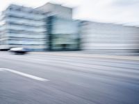 a person is riding a motorcycle on a city street and some buildings behind it, blurry
