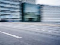 a person is riding a motorcycle on a city street and some buildings behind it, blurry