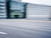 a person is riding a motorcycle on a city street and some buildings behind it, blurry