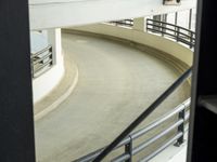 a skateboarder rides along the edge of the stairs of a building and looks on