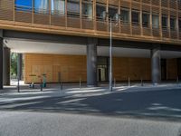 a road through which is a large modern building with an awning over it's entrance