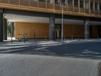 a road through which is a large modern building with an awning over it's entrance