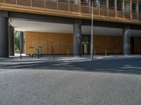 a road through which is a large modern building with an awning over it's entrance