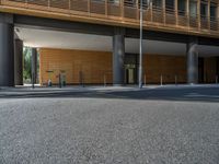 a road through which is a large modern building with an awning over it's entrance