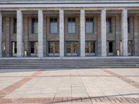 a row of stairs outside of a building with columns on each side of the entrance