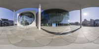 a very large modern building with many windows around it on the ground outside the structure