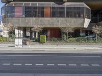 the modern building has a curved window, and the entrance is closed off from the street