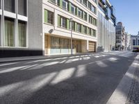 empty road with buildings on both sides in an urban setting on a clear day with no cloud coverage