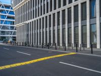 the empty street with bicycles parked in front of the buildings has a sign that says the library on it