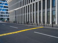 the empty street with bicycles parked in front of the buildings has a sign that says the library on it