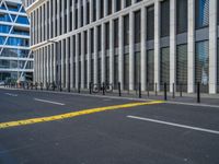 the empty street with bicycles parked in front of the buildings has a sign that says the library on it