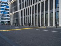 the empty street with bicycles parked in front of the buildings has a sign that says the library on it