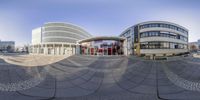 this spherical panoramic photograph shows a circular office building with windows in the middle of the buildings