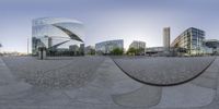 the distorted view of a city square from inside the circular mirror, with buildings in the background