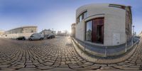 the view of a street through a circular mirror on the pavement of the city street