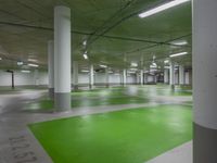 there are yellow and green floors in the large parking garage as well as some green spots