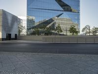 a large glass building in a city with no people on the street or in front