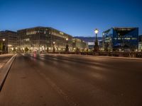 the city skyline is at night from the street level with traffic and pedestrians walking on it