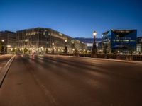 the city skyline is at night from the street level with traffic and pedestrians walking on it