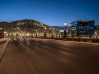 the city skyline is at night from the street level with traffic and pedestrians walking on it