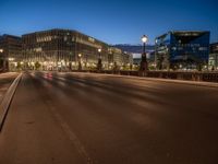 the city skyline is at night from the street level with traffic and pedestrians walking on it