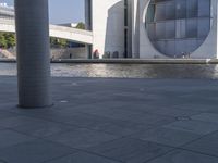 there is a man standing next to a fountain and water feature in front of a building