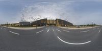 this is a circular panoramic view of a road near an office building, with a few cars driving on it