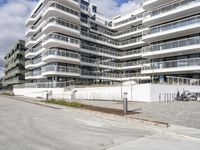 there are a number of motorcycles parked on the street near a large white building with balcon