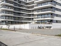 there are a number of motorcycles parked on the street near a large white building with balcon