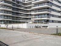 there are a number of motorcycles parked on the street near a large white building with balcon