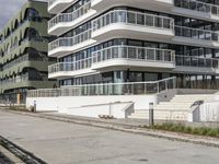 there are a number of motorcycles parked on the street near a large white building with balcon