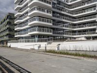 there are a number of motorcycles parked on the street near a large white building with balcon