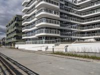 there are a number of motorcycles parked on the street near a large white building with balcon