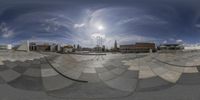 a fisheye view of a skate park with the sun in the background behind it