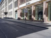 a city street with a parking meter on the side of it and a building behind it